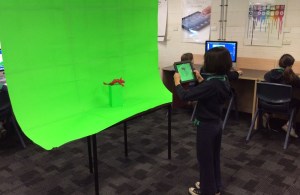 A student creating raw footage with an iPad for a Green screen movie.